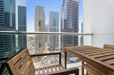 a balcony with two benches and a view of a city at Stonetree - GoldCrest Views 2 - Peaceful Community in Dubai