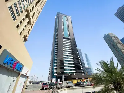 a tall building with cars parked in front of it at Stonetree - GoldCrest Views 2 - Peaceful Community in Dubai