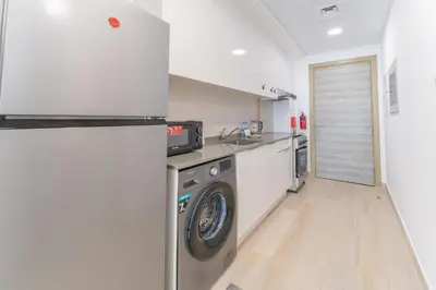 a kitchen with a washer and dryer in a room at HAVN - Studio Apartment in Bloom Towers, JVC in Dubai