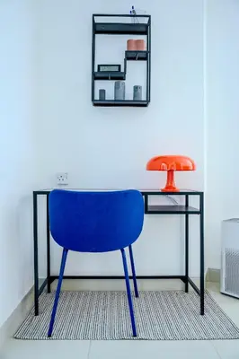 a blue chair sitting in front of a desk at New Modern Apartment 1BHK 5 min walk to Dubai Mall 99walk score in Dubai