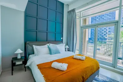 a bedroom with a large bed with two towels on it at New Modern Apartment 1BHK 5 min walk to Dubai Mall 99walk score in Dubai