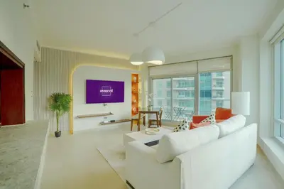 a living room with a white couch and a large window at Brand New 2BHK Luxury Apartment 7min to Dubai Mall 1.5 Bath in Dubai