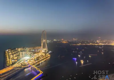 a city skyline at night with a ferris wheel at Highfloor 2-BR in Address Jumeirah Beach Residence in Dubai