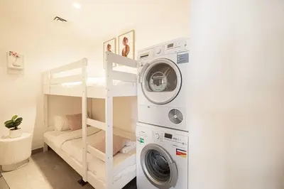a room with a bunk bed and a washing machine at Stella Maris - Beachfront Premium 3 Bedroom Apt in Dubai