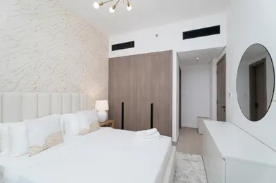 a bedroom with a white bed and a mirror at Nasma Luxury Stays - Laya Heights in Dubai