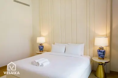 a bedroom with a white bed with two lamps at Veluxa - Stunning Sea View - Luxe 3 Bed in La Mer in Dubai