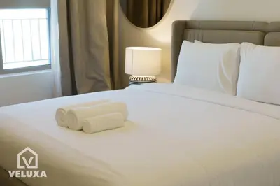 a white bed with two rolled towels on it at Veluxa - Stunning Sea View - Luxe 3 Bed in La Mer in Dubai