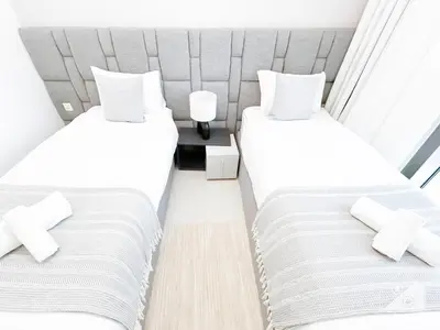 two beds in a small room with white walls at Luxury & Elegance at Burj Crown Downtown in Dubai