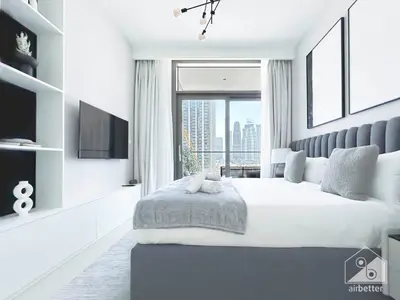 a white bedroom with a large bed and a window at Luxury & Elegance at Burj Crown Downtown in Dubai