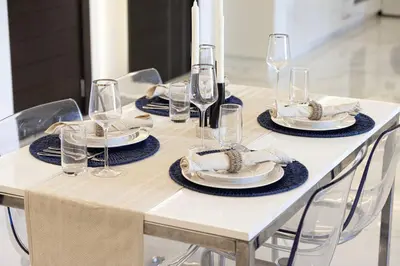 a white table with glasses and plates and napkins at Luxe 2-Bedroom In Heart Of Dubai Marina in Dubai