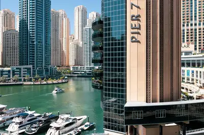 a river with boats in a city with tall buildings at Luxe 2-Bedroom In Heart Of Dubai Marina in Dubai