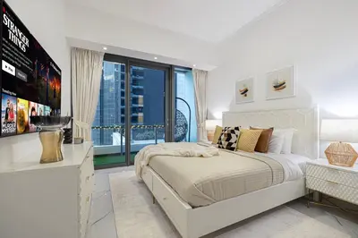 a white bedroom with a bed and a large window at Luxe 2-Bedroom In Heart Of Dubai Marina in Dubai