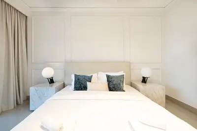a bedroom with a large white bed with two tables at Stunning Burj & Fountain Views Luxury 2 BR in Dubai