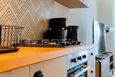 a kitchen with a stove top oven next to a wall at New Cozy 1BR Dubai Hills in Dubai