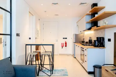 a kitchen with a table and chairs in a room at New Cozy 1BR Dubai Hills in Dubai