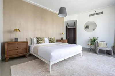 a bedroom with a large white bed and a chair at Frank Porter - Opera Grand in Dubai