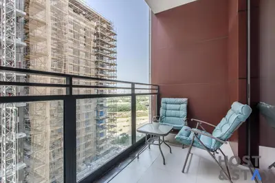 a balcony with two chairs and a large window at Boutique Studio in Wilton Park MBR City in Dubai