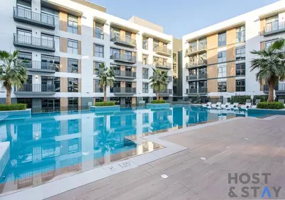 a swimming pool in front of a apartment building at 1BR Belgravia Apartment with pool view in Dubai