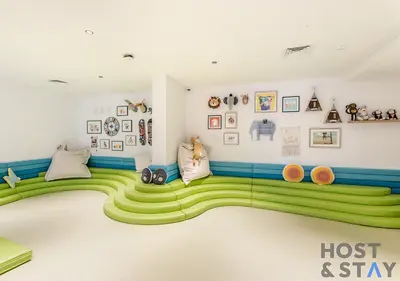 a childs room with a green carpeted floor at 1BR Belgravia Apartment with pool view in Dubai