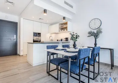 a kitchen and dining room with a table and chairs at Comfy 1BR at JVC - Ideal for Family & friends in Dubai