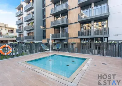 a swimming pool in front of a apartment building at Comfy 1BR at JVC - Ideal for Family & friends in Dubai