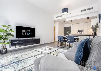 a living room with a couch and a tv at Comfy 1BR at JVC - Ideal for Family & friends in Dubai