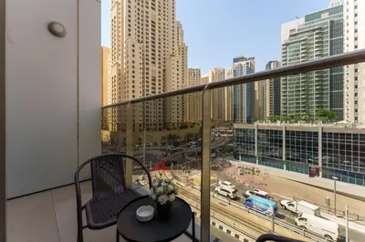 a balcony with a table and a view of a city at Your gateway in Sparkle Tower JBR by Suiteable in Dubai