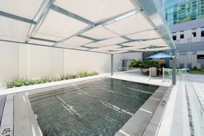 a swimming pool in a building with an umbrella at DAMAC APARTMENTS in Dubai