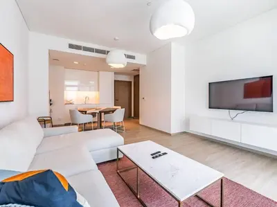 a living room with a white couch and a table at The Harbor Heights 1BR in Palace Residences Creek in Dubai