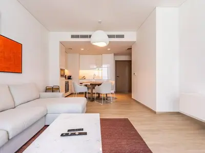 a living room with a white couch and a table at The Harbor Heights 1BR in Palace Residences Creek in Dubai