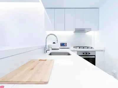a white kitchen with a sink and a stove at Stylish 1Bedroom with Balcony & View Dubai in Dubai