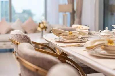 a table with chairs and cups and dishes on it at Elite Royal Apartment - Panoramic with Burj Khalifa & Full Fountain View - High Floor - Patron in Dubai