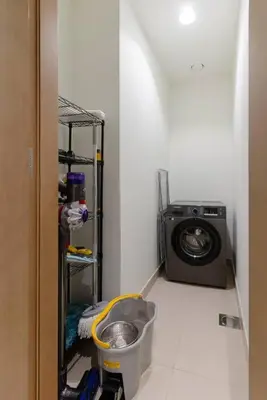 a bathroom with a washing machine in a room at Stylish and Cozy l Park View l Next to Mall in Dubai