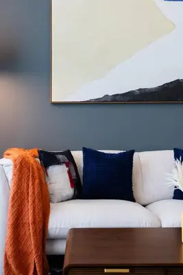 a living room with a white couch with pillows at Stylish and Cozy l Park View l Next to Mall in Dubai