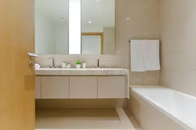 a bathroom with a sink and a tub and a mirror at Stylish and Cozy l Park View l Next to Mall in Dubai