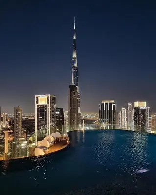 a view of a city skyline at night at 64th-Floor Rooftop Pool with Burj Khalifa View, 2BR Apartment in Paramount Hotel Midtown in Dubai