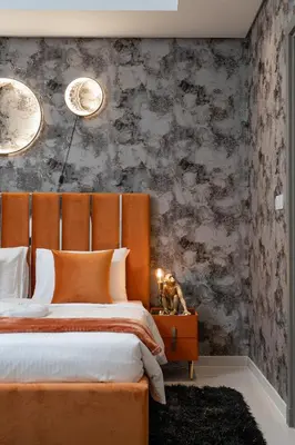 a bedroom with a bed with an orange headboard at 64th-Floor Rooftop Pool with Burj Khalifa View, 2BR Apartment in Paramount Hotel Midtown in Dubai