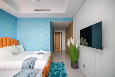 a bedroom with two beds and a blue wall at 64th-Floor Rooftop Pool with Burj Khalifa View, 2BR Apartment in Paramount Hotel Midtown in Dubai