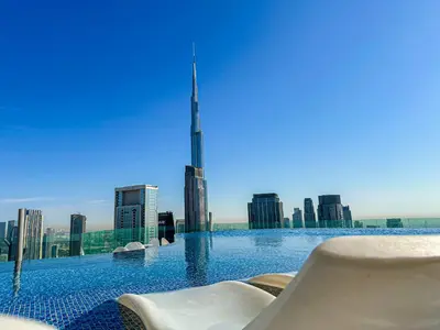 a swimming pool with a view of the burj khalifa at 64th-Floor Rooftop Pool with Burj Khalifa View, 2BR Apartment in Paramount Hotel Midtown in Dubai