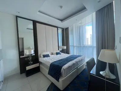 a hotel room with a bed and a large window at Damac Maison Distinction in Dubai