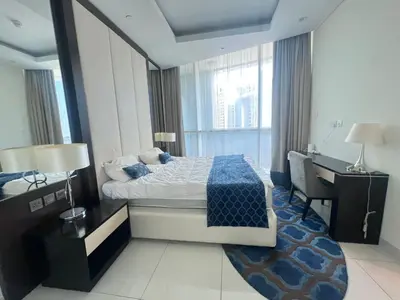 a hotel room with a bed and a desk and a desk at Damac Maison Distinction in Dubai