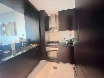 a kitchen with black cabinets and stainless steel appliances at Damac Maison Distinction in Dubai