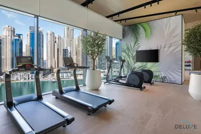 a gym with cardio equipment and a view of a city at Chic 1BR in VIDA Residences Dubai Marina by Deluxe Holiday Homes in Dubai