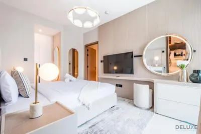 a white bedroom with a large bed and a mirror at Chic 1BR in VIDA Residences Dubai Marina by Deluxe Holiday Homes in Dubai