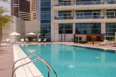 a swimming pool in front of a building at Marina Seaside Living prime location by the beach in Dubai