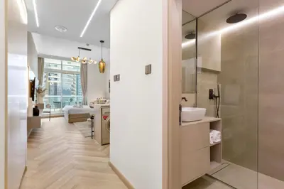 a bathroom with a glass shower and a sink at Marina Seaside Living prime location by the beach in Dubai