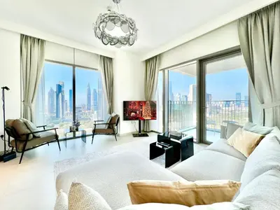 a living room with a white couch and large windows at Downtown Views 2BR - Dubai Mall, Fountain & Burj Khalifa access in Dubai