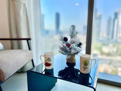 a glass table with a christmas tree and two cups at Downtown Views 2BR - Dubai Mall, Fountain & Burj Khalifa access in Dubai
