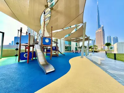 a playground with a slide and swings at Downtown Views 2BR - Dubai Mall, Fountain & Burj Khalifa access in Dubai