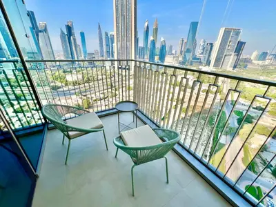 a balcony with two chairs and a view of the city at Downtown Views 2BR - Dubai Mall, Fountain & Burj Khalifa access in Dubai